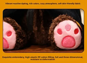 Close-up of teddy bear plush with pink embroidered paws and soft long-hair fabric detail