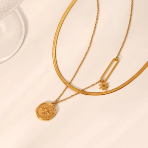 Detailed view of layered gold blade chain and hexagonal starburst pendant necklace