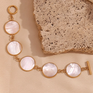 Detail of 18K gold-plated stainless steel bracelet with white pearl shells and toggle clasp