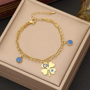 Double-layered gold stainless steel necklace with clover and evil eye charms on velvet box