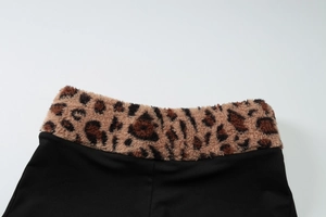 Gros plan de la taille montrant le tissu noir et la bordure en peluche imprimé léopard