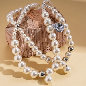 Close-up of elegant multi-layer pearl necklace with pear-shaped crystal pendant