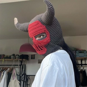 Detail of handmade crochet balaclava with devil horns in gray and red contrast knit