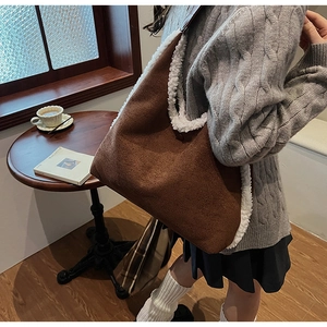 Brown faux suede shoulder bag with white fleece trim shown in a cozy cafe setting