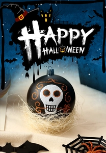 Detail of matte black Halloween skull ornament with orange glitter in a rustic straw nest