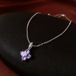 Macro view of flower pendant featuring purple heart-shaped zircons on a silver chain