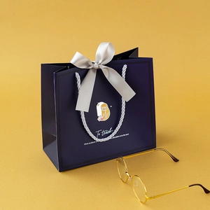 Elegant deep blue teacher gift bag with satin bow and illustration on yellow background