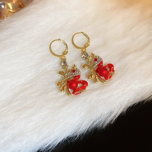 Detail view of New Year Fu character earrings with red crab design and pearl accents