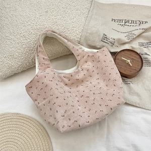 Détail d'un sac cabas en velours côtelé rose avec motif floral de style chic français