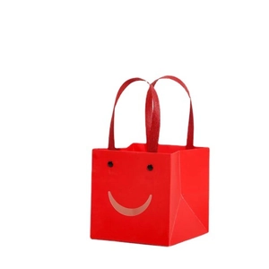 Red square paper gift bag with minimalist smile face pattern and sturdy ribbon handles