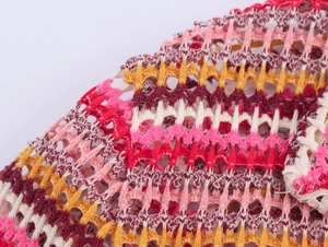 Macro view of multi-color striped crochet knit fabric with wavy hollow-out patterns