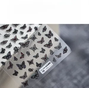 Detailed close-up of 5D embossed nail art stickers featuring dark red butterfly patterns