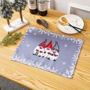 Close-up of a festive Christmas placemat featuring cute Gnomes on a wooden table setup