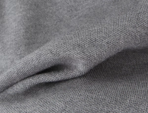 Detailed close-up of grey knit fabric texture showing the soft ribbed material quality