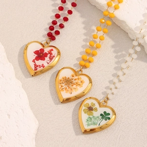 Detail view of heart lockets with dried flowers and colorful crystal beaded chains