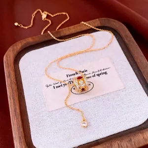 Gold plated gourd necklace with red enamel and pavé zircons in elegant still life setup