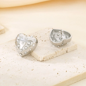 Gros plan sur des boucles d'oreilles cœur argentées ornées de strass brillants