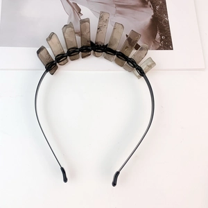 Detailed view of grey crystal crown crown with black wire wrapping on headband