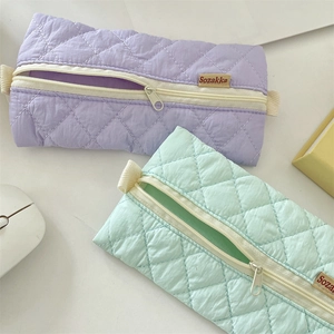 Detailed view of quilted lilac and mint pencil cases with Sozakka brand labels