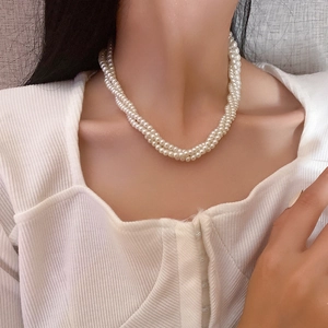 Dettaglio della collana di perle a due strati indossata per un look elegante e lucido