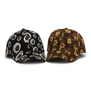 Detail view of cotton baseball caps featuring black floral patterns and brown letter prints