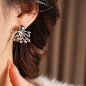 Macro shot of silver fireworks earrings with grey pearls and sparkling crystals