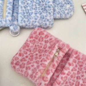 Makroansicht der flauschigen Leoparden-Geldbörsen in Rosa und Blau mit Reißverschluss