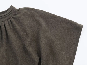 Detail of high neck pleated design on dark grey fashion mini dress with fabric texture