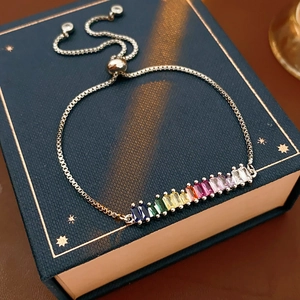 Detail of adjustable rainbow gemstone bracelet with rectangular crystals on a blue box