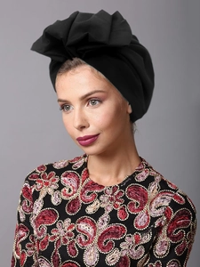 Detailed close-up of a women's black pleated turban hat with elegant draped fabric texture