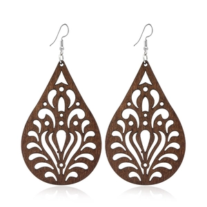 Détail de boucles d'oreilles en bois en forme de goutte avec gravures botaniques