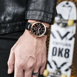 Detailed close-up of a men's quartz watch with a rose gold case and black leather strap
