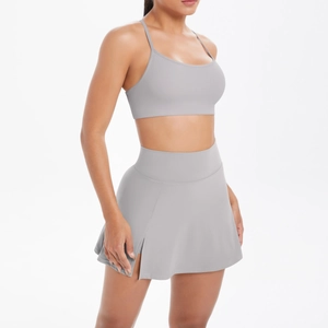 Détail ensemble de yoga gris avec haut à fines bretelles et jupe de tennis à taille haute