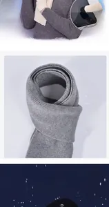 Detail of gray knitted scarf and cream touch screen gloves for winter warmth set