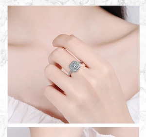 Detailed view of an elegant silver wide band ring with square zircon on a female hand