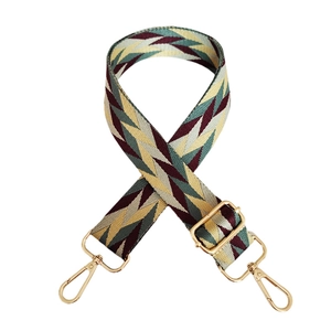 Adjustable woven shoulder strap with green and yellow geometric patterns and gold metal clips