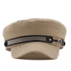 Detail of khaki baker boy hat with sparkling rhinestone band and metallic side buckles