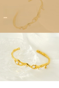 Detailed macro view of 18K gold plated wavy steel bracelet with elegant white pearls