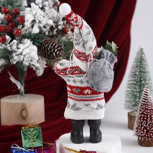 Detail of Christmas plush doll back with red knit pattern and grey sack decoration