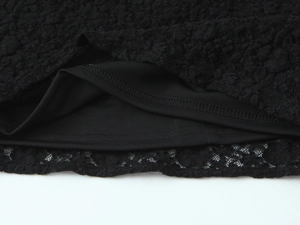 Gros plan de l'ourlet en dentelle noire montrant la texture mesh et la double couture