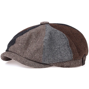 Detail of multi-color herringbone patchwork newsboy cap with a small metal logo plaque