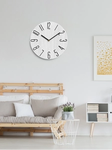 Detail of modern wall clock with white wood texture dial and 3D black numerals