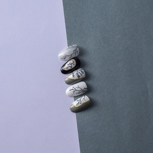 Detailed view of 5D black crackle marble nail stickers with gold accents and almond shape