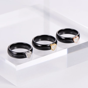 Macro shot of ceramic rings with crystal heart accents in gold, silver, and rose gold