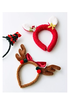 Flat lay detail of plush reindeer antler headbands with Christmas bows and tree accents