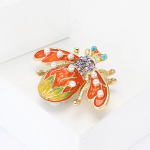 Creative enamel bee brooch with pearls and colorful rhinestones on a white pedestal