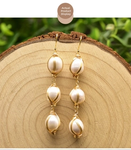 Macro view of long vintage 925 silver wire-wrapped natural freshwater pearl drop earrings