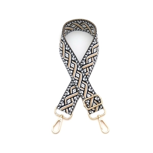 Détail de la bandoulière en tricot géométrique avec mousquetons en métal doré poli