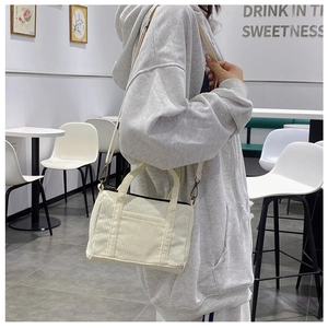 Detail of off-white corduroy Boston bag with shoulder strap and bronze zipper