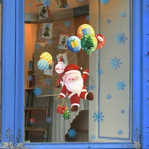 Detail of Santa and snowman Christmas window stickers on glass with a cozy indoor view